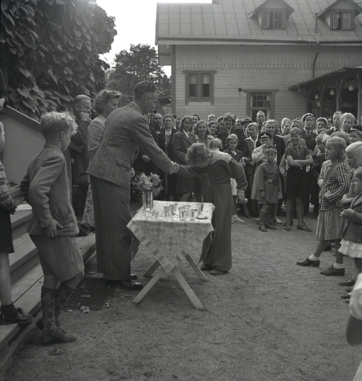 Simningen, 16/8 1942. 
Prisutdelning på Evedal. En pojke i träningsoverall får en liten 
bägare i pris.