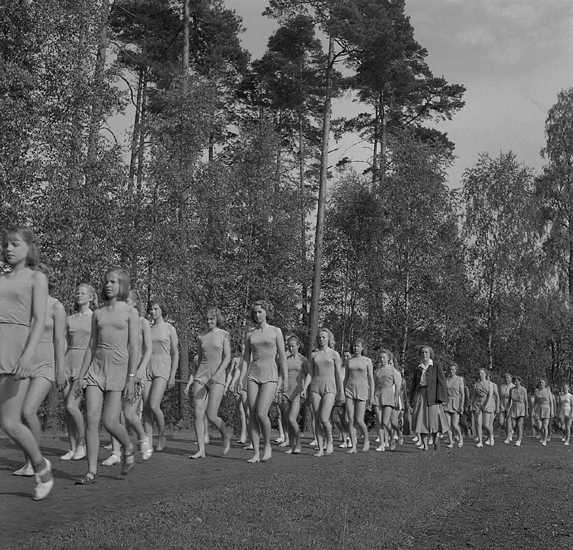 Gymnastiken på Värendsvallen, 24 maj 1949. 
En flicktrupp (tonårsflickor) med ledare, tågar in.