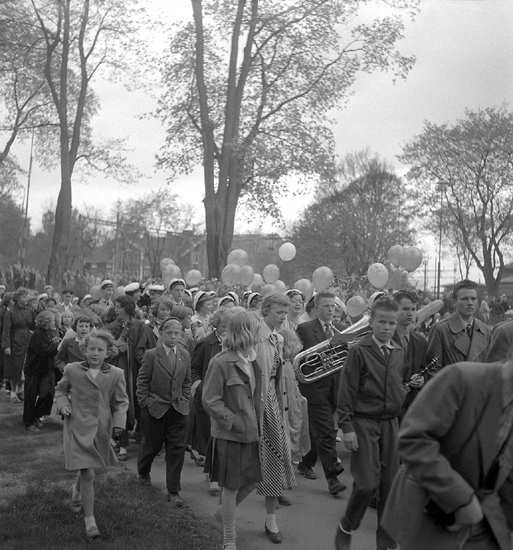 Studenterna andra dagen, 18/5 1954. 
Studenter och anhöriga m.fl. på väg in i Linnéparken och talet vid Esaias Tegnérs staty. 
I bakgrunden skymtar Domprostgården.