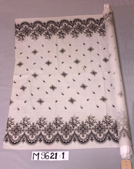 Gardin av vit maskinvävd bomull, med tryckt mönster i svart. 
Bred bård och strödda buketter och stjärnor. 
Inskrivet i huvudkatalogen 1937.
Funktion: Fönstergardin
