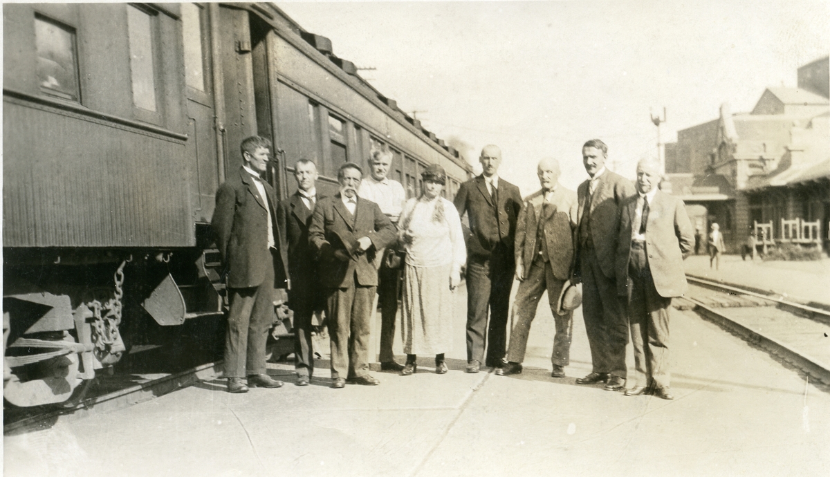 Ei kvinne og åtte menn står utenfor et tog i Minneapolis 5. juni 1925. Olaus Islandsmoen er nr. 4 fra høyre.