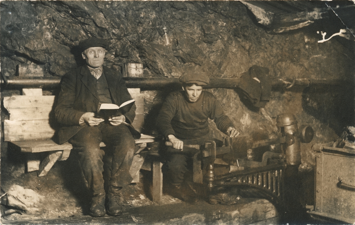 To gruvearbeidere i gang med veiing av kisvogner i gruva.