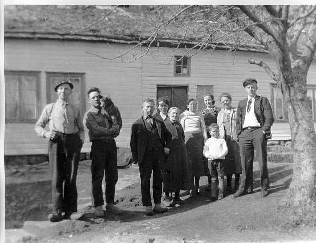 Familien Omdal og familien Løvold samlet på tunet ved et bolighus på Nedre Omdal
