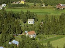 Bolighus med overbygd veranda. Inngjerdet hage. Grantrær run