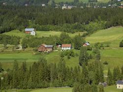 Kolbotten. Gårdsbruk med hvit bygning og rødbrunt uthus i vi