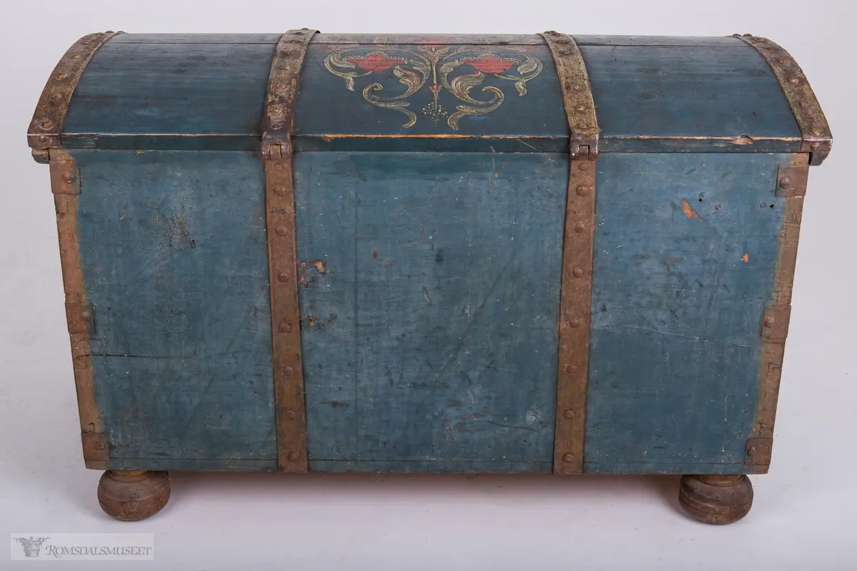 Rosemaling på blå bunn.  Det midtre feltet er dekorert med symetrisk rosemaling på blå bunn . I de to andre feltene på fronten er malt med initialene.