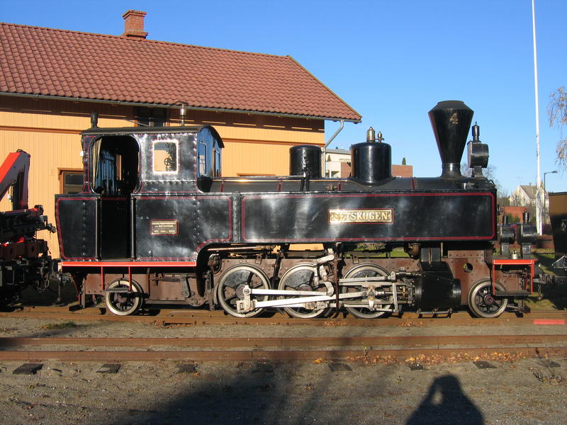 Damplokomotiv kalt Setsskogen. I bagrunnen Urskog-Hølandsbanens okergule stasjonsbygning.