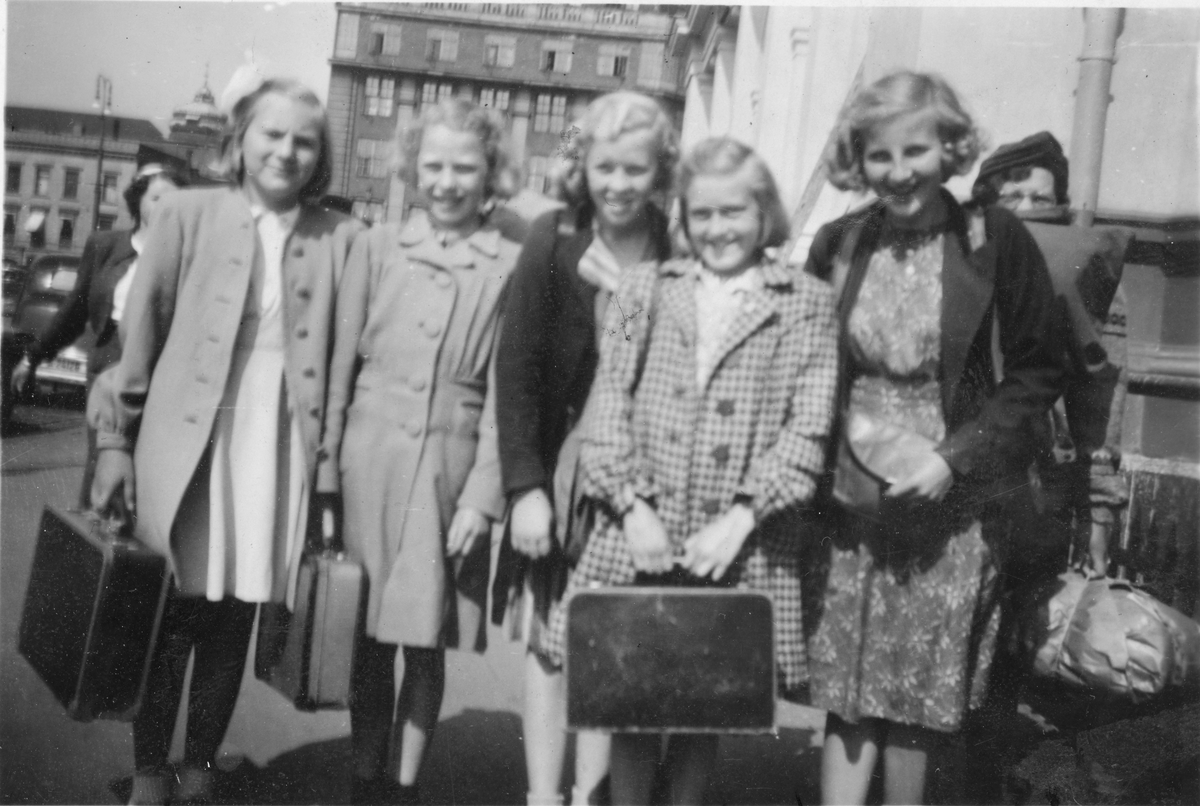 5 jenter på tur med koffert.