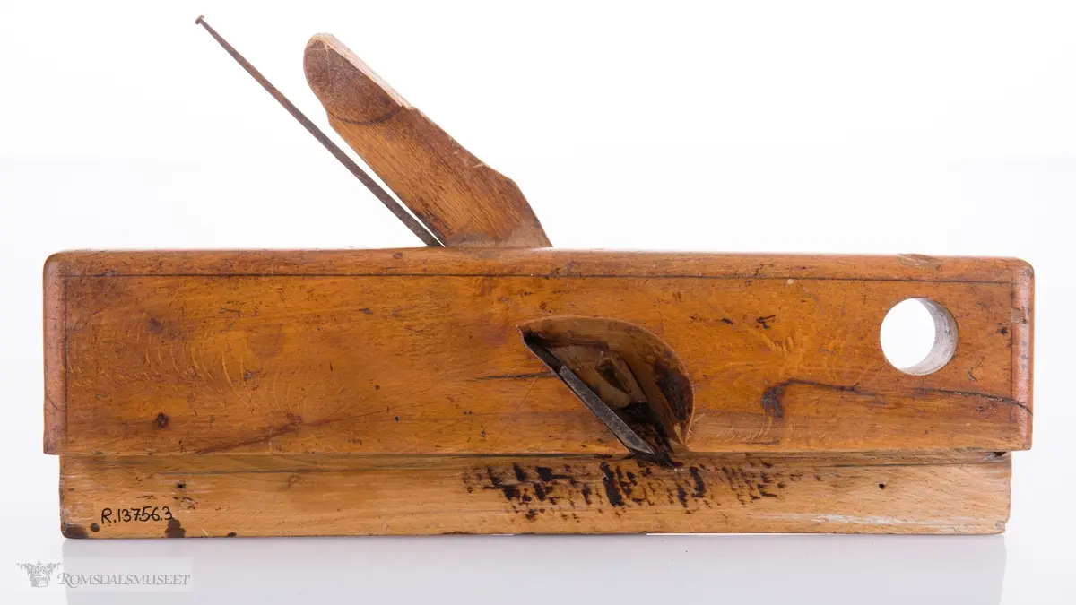 Smal høvel med hesteskoformet jern for høvling av fjær. Den ene siden av høvelen har en støtteskinne.