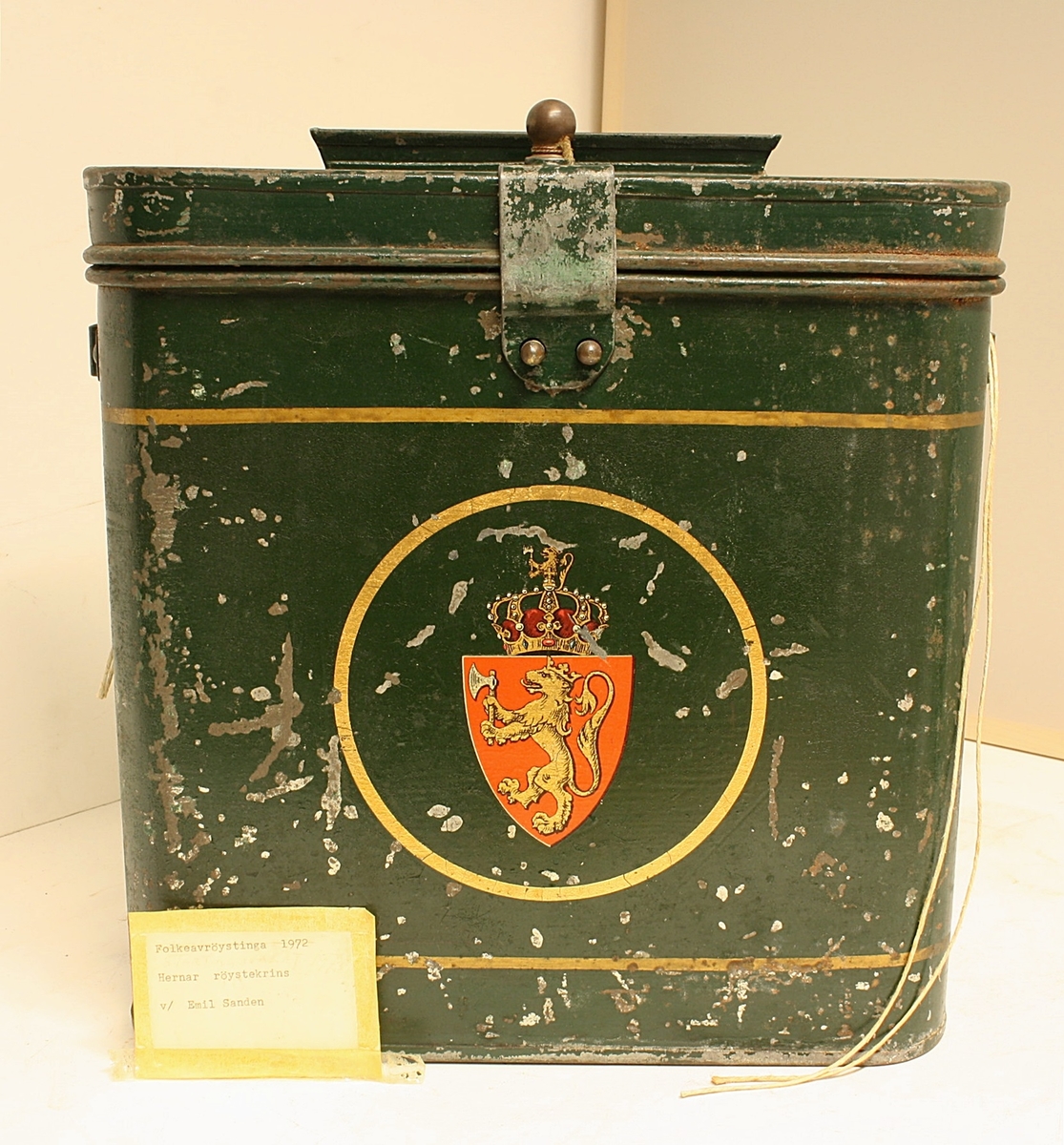 Avrundet, rektangulær boks. Den norske løve på fronten. Rødt segl på begge kortsidene. Hvit hyssing.