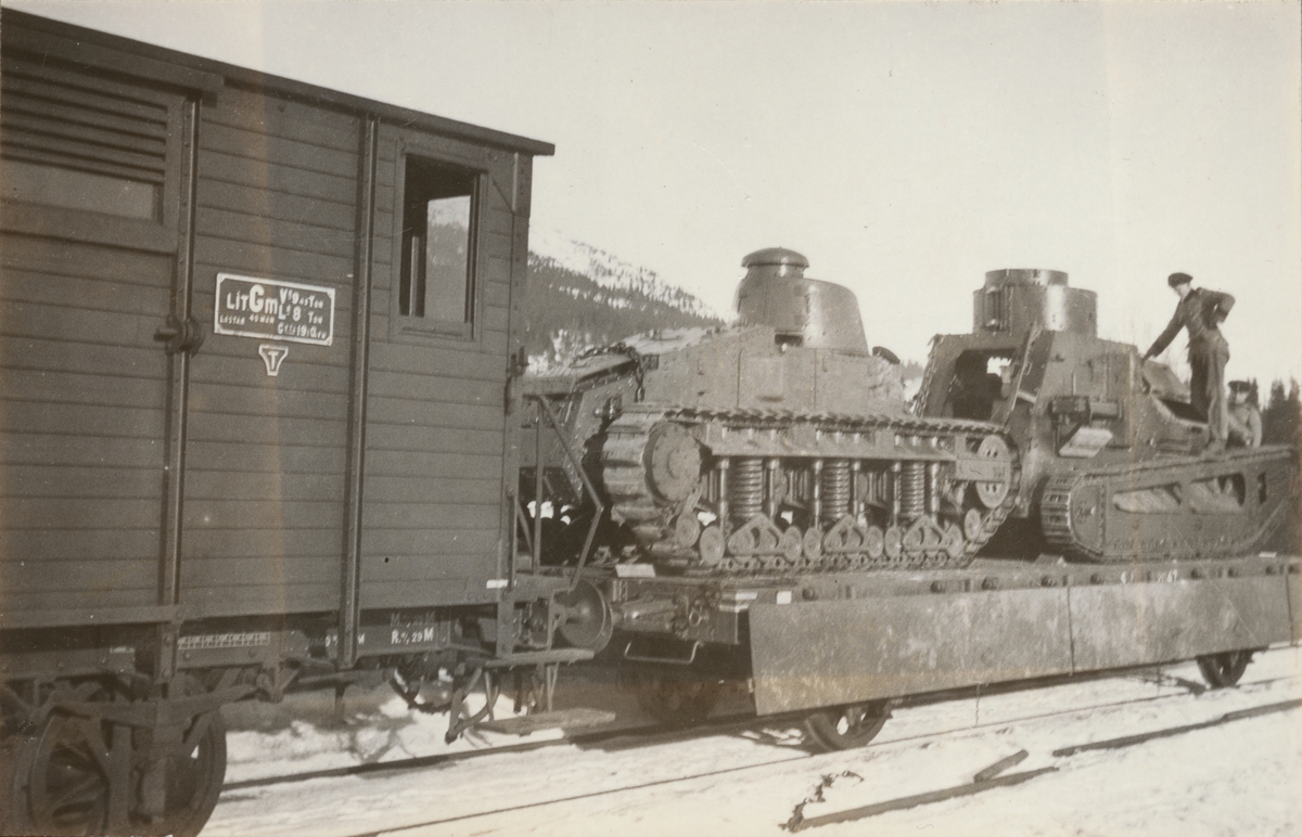 Två stridsvagnar m/1921 (eller m/1921-1929) lastade på tåg. Två soldater står och kontroller lastningen.