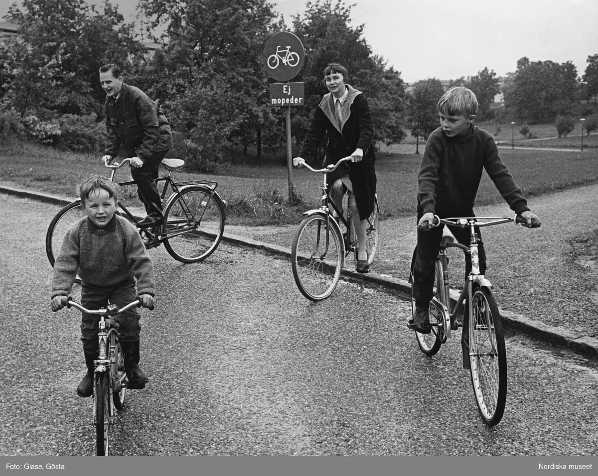 Olof Palme med hustru och söner cyklar på en cykelbana i Vällingby.