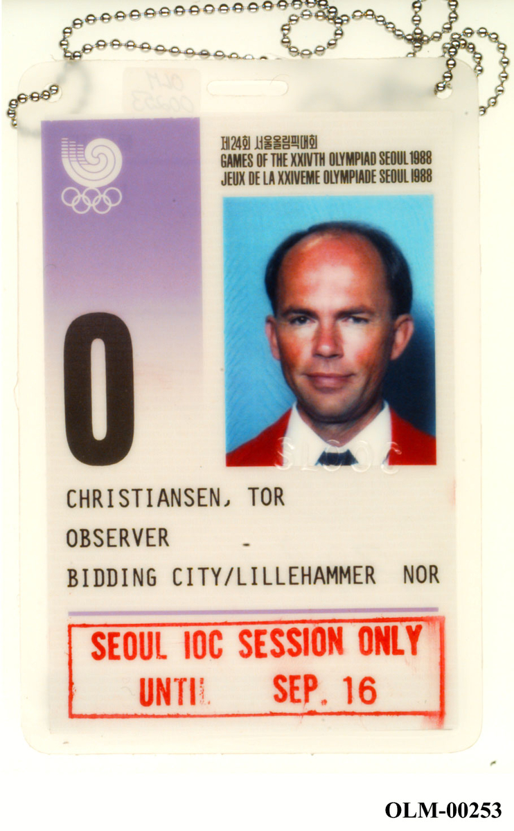 Rektangulært laminert kort med kjede. Øverst til venstre logo for Sommer-OL i Soul 1988, til høyre portrettbilde av Tor Chistiansen. Over bildet et vannmerke med tekst SLOOC. Tekst over tre linjer og stempel nederst på kortet.
