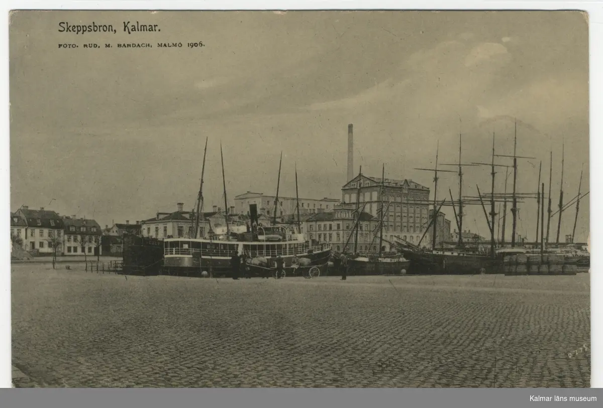 Skeppsbron i Kalmar med kvarnbyggnaderna samt ångbåt och segelskutor i hamnen.