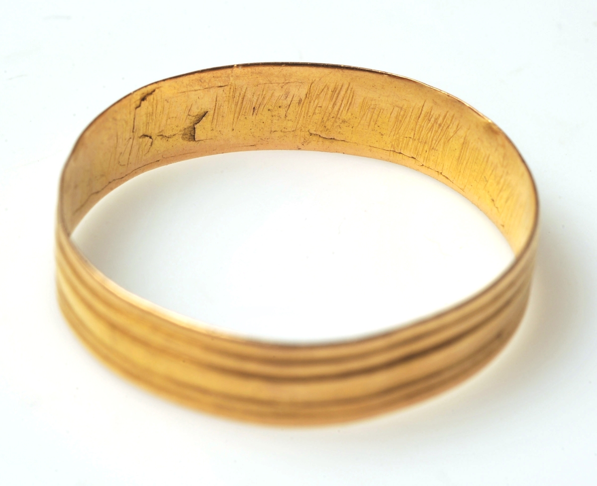 Ring av guld, något ojämnt cirkulär. Fyra skåror löper längs med ringens form.

Typ 10 variant Ib och typ 11 variant Ic (Kent Andersson, Romartida guldsmide i Norden, 1993, vol II Fingerringar).
