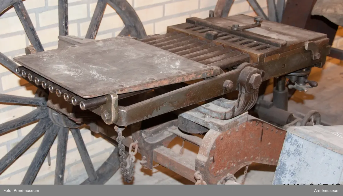 Grupp E IV a.

Detta är den första tillverkade kulsprutan av Palmcrantz & Winborg m/1875. Dock finns inget skrivet på tillverkningsplåten med uppgifter om tillverkare och år. Däremot syns tillverkningsnumret.
Magasin saknas liksom patronledare och verktyg. Se stämpel på insidan av verktygslådans lockstöd.