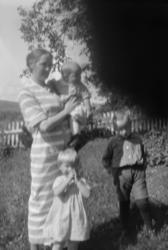 Foto av en kvinne med tre små barn. Mest sannsynlig i slekt 