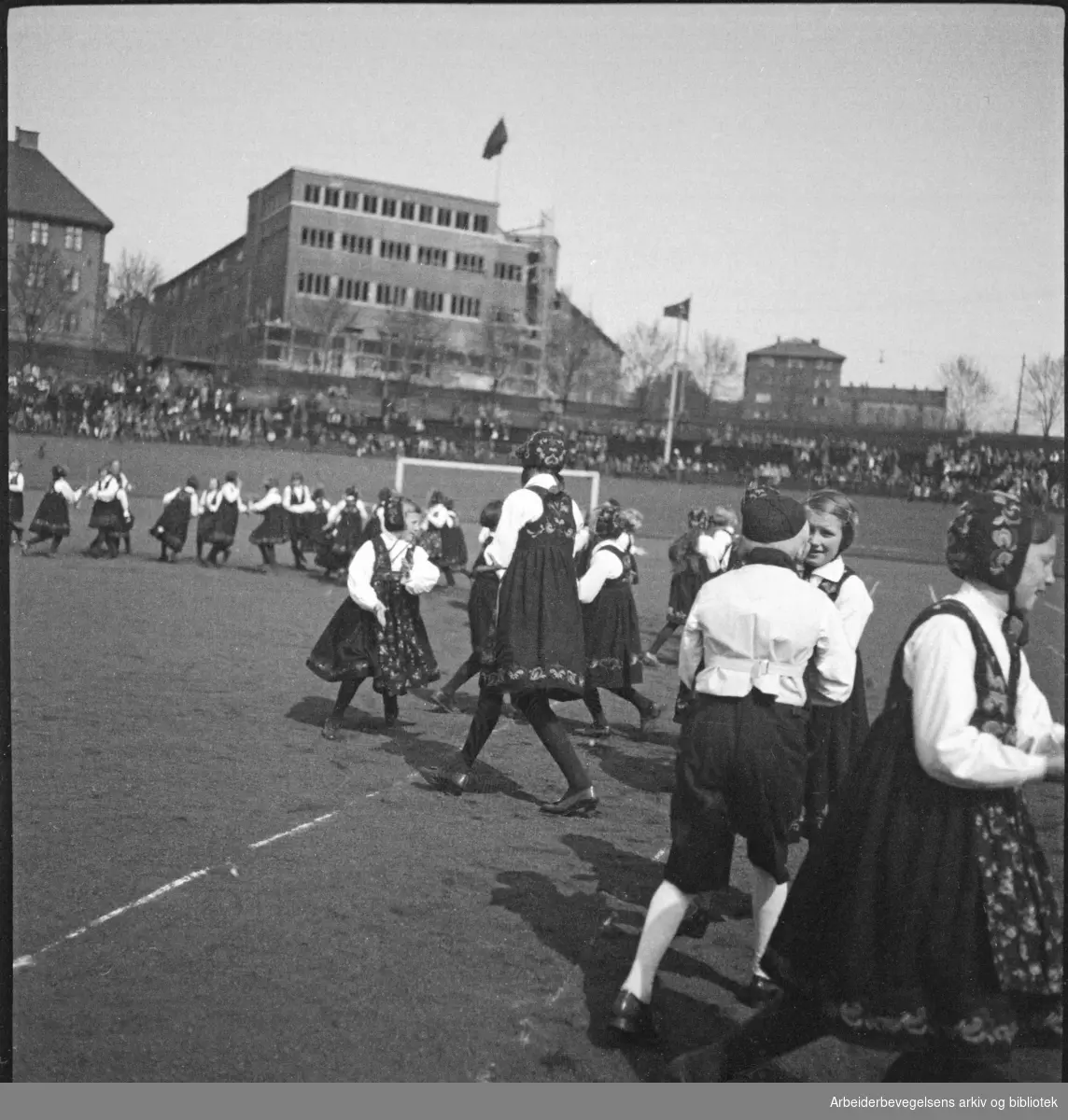 1. Mai 1932 på Dælenenga i Oslo. Barnelagene i Oslo fremfører leikarring. Grünerløkka Folkets hus i bakgrunnen.