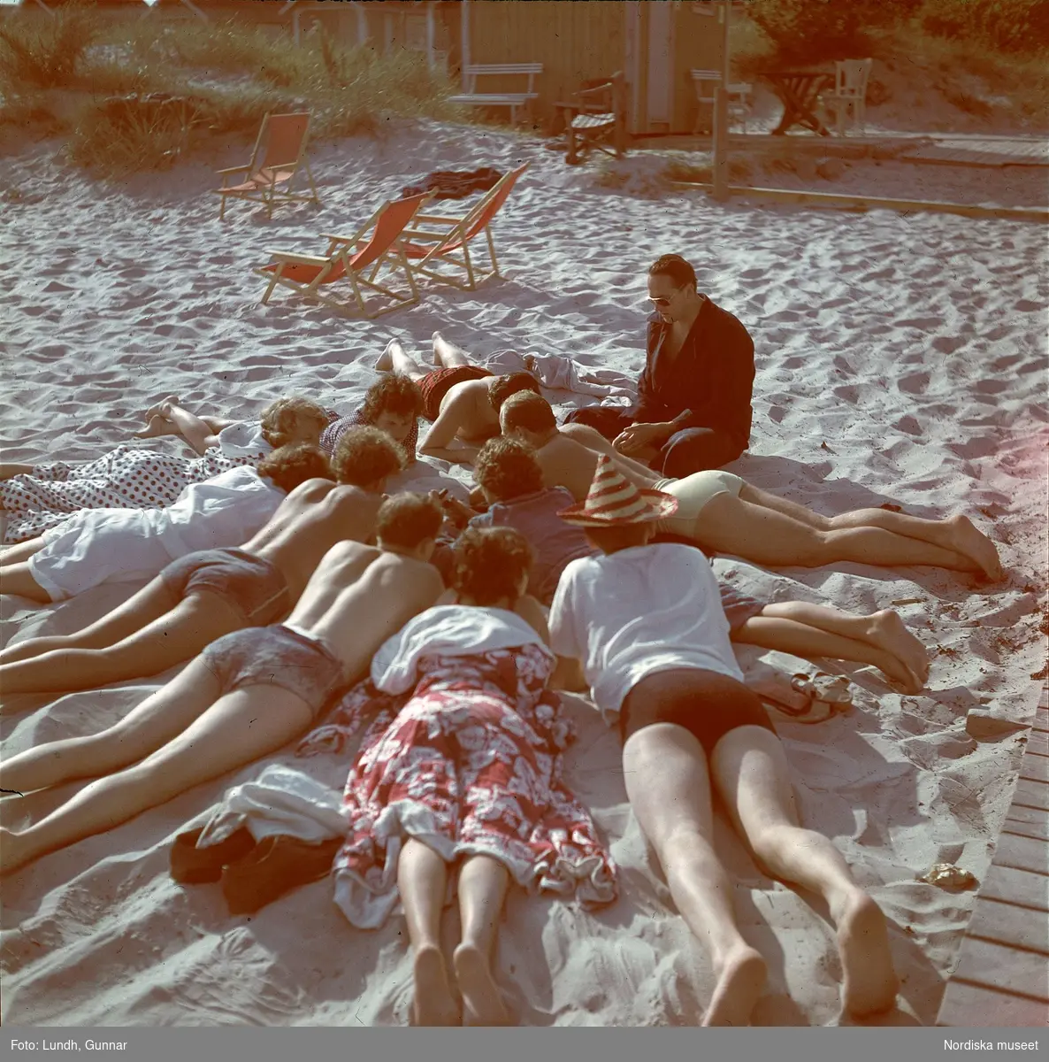 En grupp ungdomar på sandstrand.