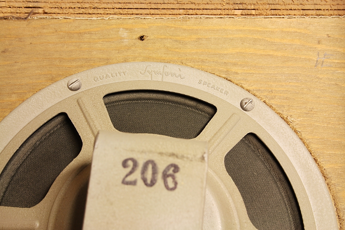 Trapesformet høyttaler til montering på vegg. Brukt på skole. Noe slitt i lakken, noe krakkelering.