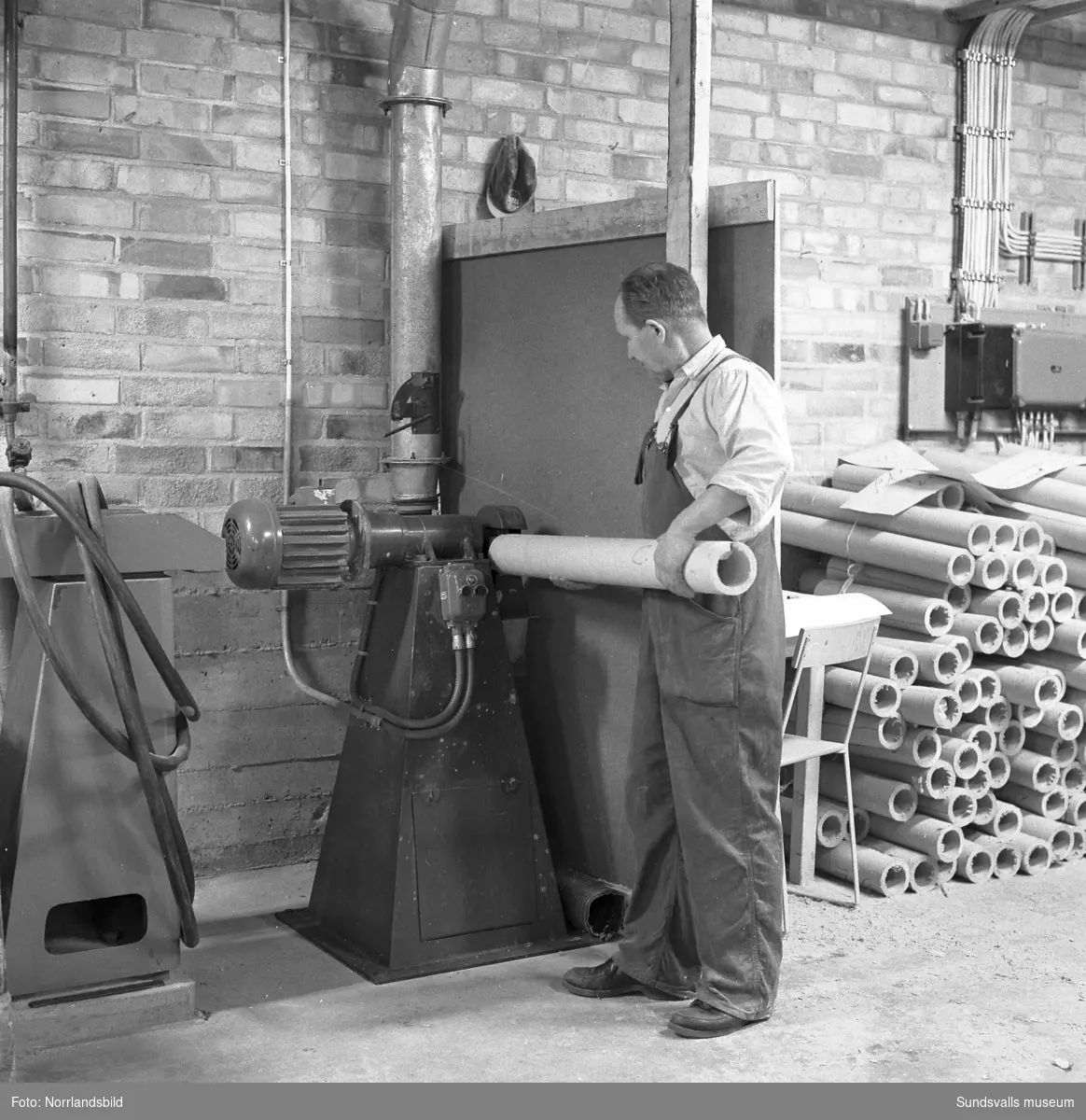 En serie bilder från Ortvikens pappersbruk, exteriörer och interiörer med olika maskiner. Bland annat en transportör från Nordströms linbanor.
