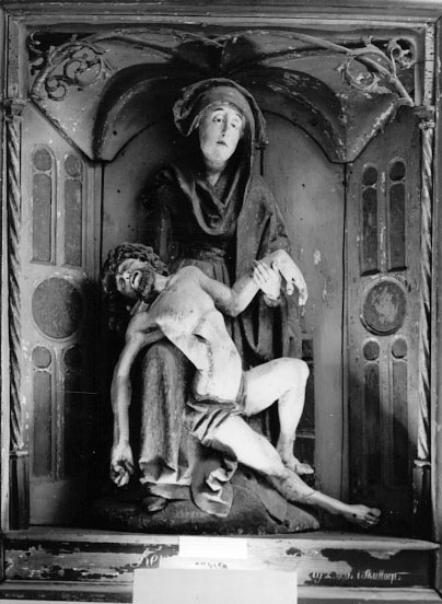I Västergötlands museums samlingar. 
Inv.nr. 7798.

PietÃ , framställning av den sörjande jungfru Maria, sittande med den döde Kristus i sitt knä. Motivet har sin bakgrund i senmedeltidens passionsmystik och uppstod i Rhenområdet i början av1300-talet. Det blev därefter vanligt i både måleri och skulptur. En ensam sörjande Maria kallas mater dolorosa. 
http://www.ne.se/jsp/search/article.jsp?i_art_id=283310