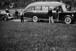 En personbil og rutebuss på veien.