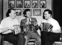 Personer, klær, trekkspill, bilder. Ottar E. Akre i midten.