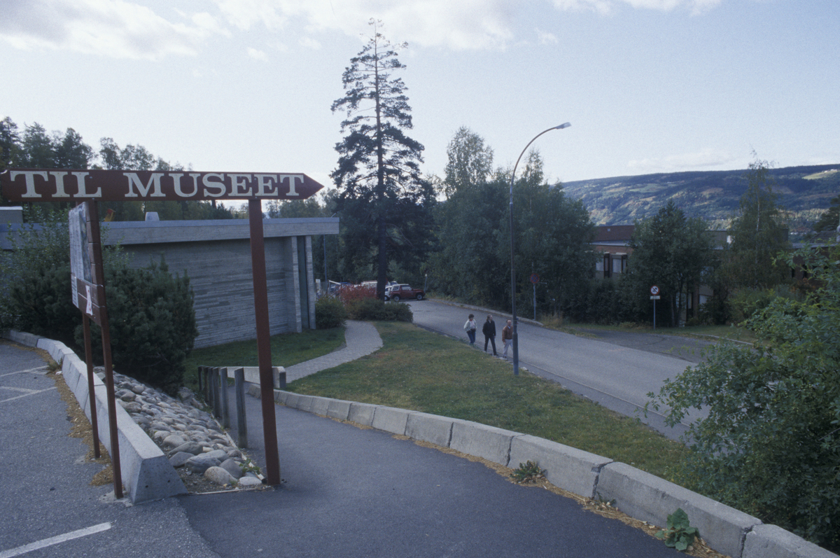 Lillehammer, Maihaugvegen med gangvei fra øvre parkerinsplass, utsikt. Lillehammer Sanitetsforenings Revmatismesykehus skimtes til høyre.