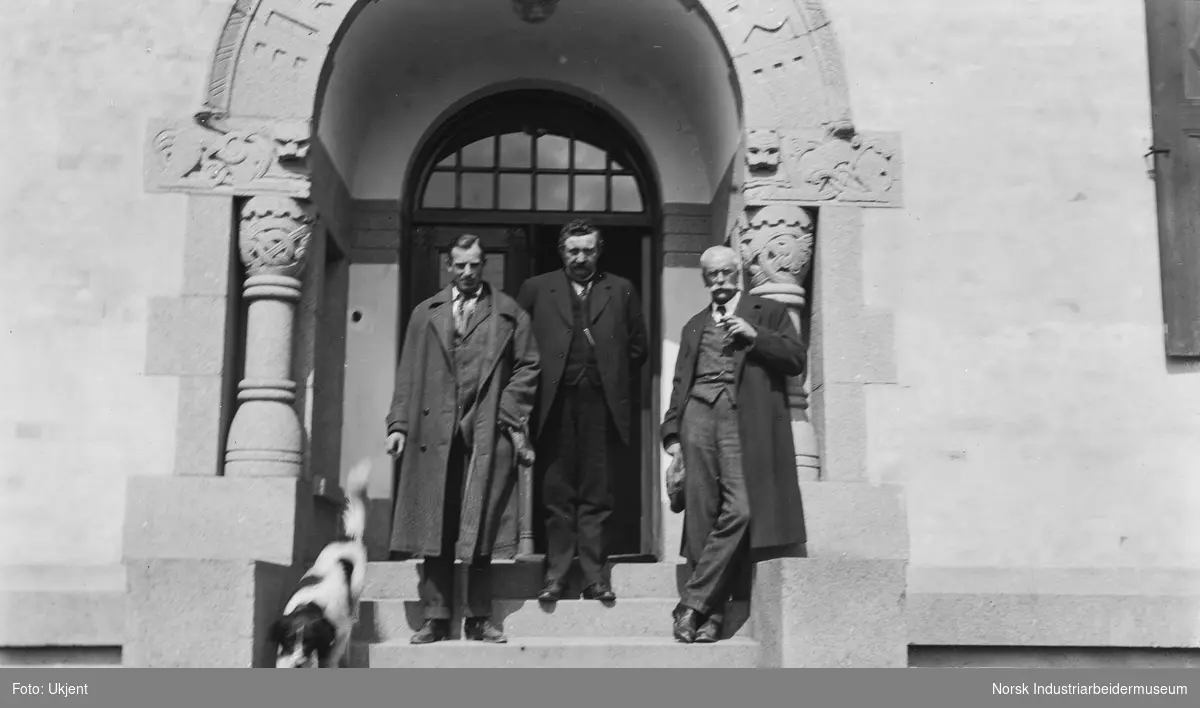 Tre menn på trappen foran kontorbygget til Tinfos AS. Ole Halvorsen Holta i midten. Antagelig under et besøk av Norsk Hydros Harald Bjerke (til høyre). 