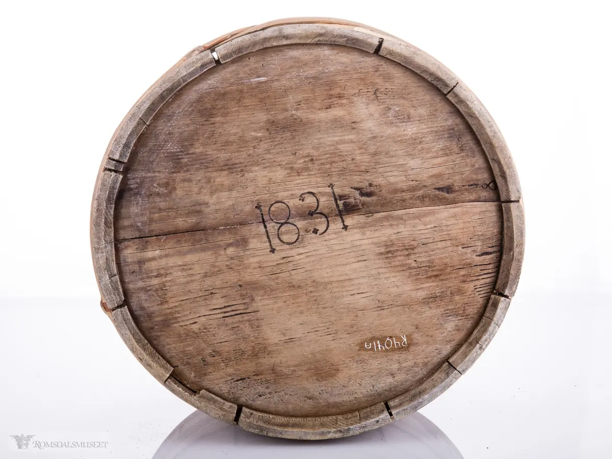 Lagget ambar med ører og lokk med hanke. Omslått med gjorder oppe og nede.