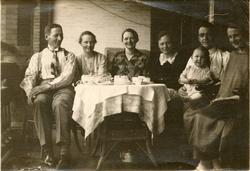 Gruppe. Skrevet bakpå: "Tat på verandaen her hvor vi nu bor.