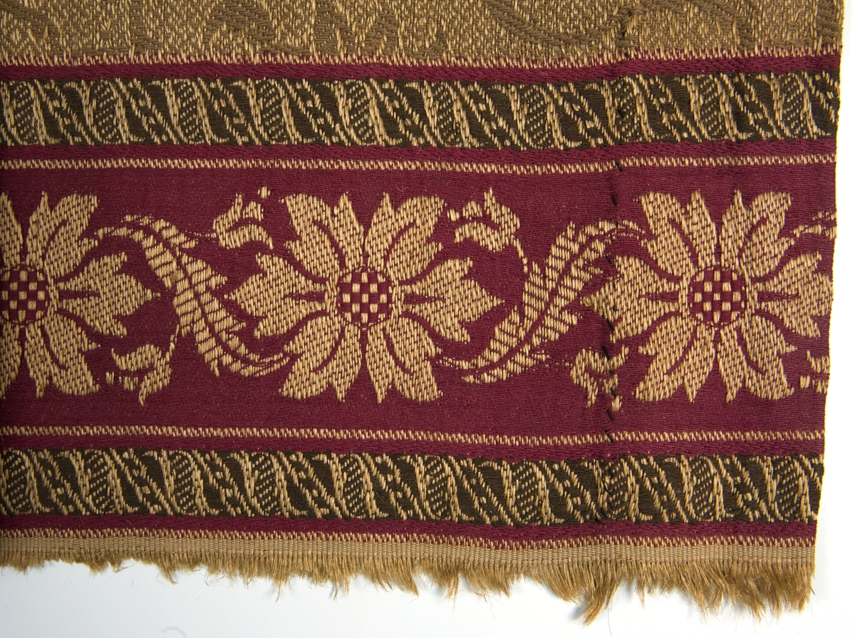 Damaskvevd gardin med en kant i rødt.