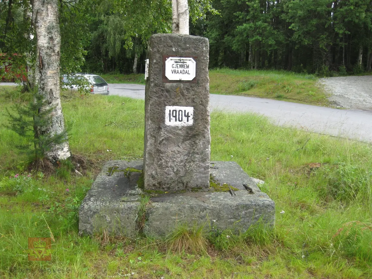 "Ved Krosli 09.08.1926", i følge merking på bildet. På bildet står et stort betongvegmerke med innhugget årstall: "Gjennem Vraadal 1904". Damen på bildet er muligens Christine Baalsrud, vegdirektørens kone. Han står til høyre for henne med skyggelue. Personene nr. 3 og nr. 6 fra venstre er de samme  som er avbildet på bilde NVM 00-F-3579. De er ukjente. 

De neste bildeframvisningene i farger viser "Vegmerke i Krossli." Sitat gjengitt fra Krossli-lokalhistoriewiki.no. Foto: Olav Momrak Haugan: "Krossli er eit vegkryss i Tokke kommune som ligg på vegen frå Bandaksli til Fyresdal. I 2011 går Rv 355 nordover frå Fyresdal til Krossli. Bandakslivegen, vegen fra Bandaksli til Fyresdal, vart i fyste del av 1900-talet grundig utbedra. Frå denne perioden finnast det fleire vegmerke som fortel vegfarande kor vegen fører vidare. Ei slik støtte stod midt i krysset i Krossli, i 2011 står den i utkanten av krysset. Litt lenger sør vert ein gjort merksam på at ein kryssar grensa til Fyresdal, etter fyrst å ha vore eit lite stykke gjennom Kvitseid kommune". 

Ref. til verneplanen "Vegvalg-Nasjonal verneplan for veger, bruer og vegrelaterte kulturminner. Statens vegvesen-Region Sør". Jfr. "202 Bandaksli", side 206. Se vedlegg.