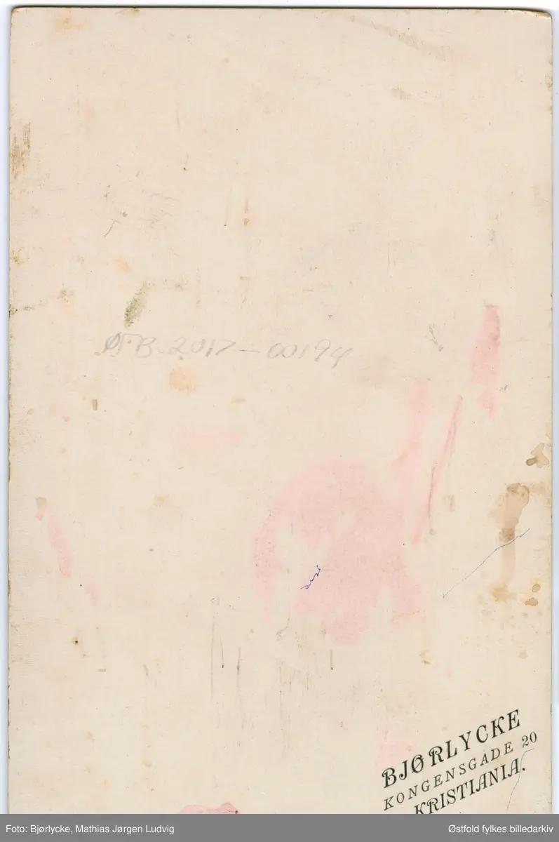 Portrett i kabinettformat tatt i atelier av ukjent kvinne og mann med barn, ca. 1897- 1902.