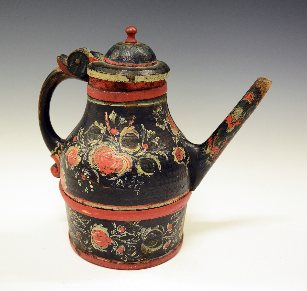 Tutekanne i tre. Fra protokollen: Ølkande med tut, laak og hank; dreiet arbeide i 2 halvdeler; rosemaling paa sort bund.