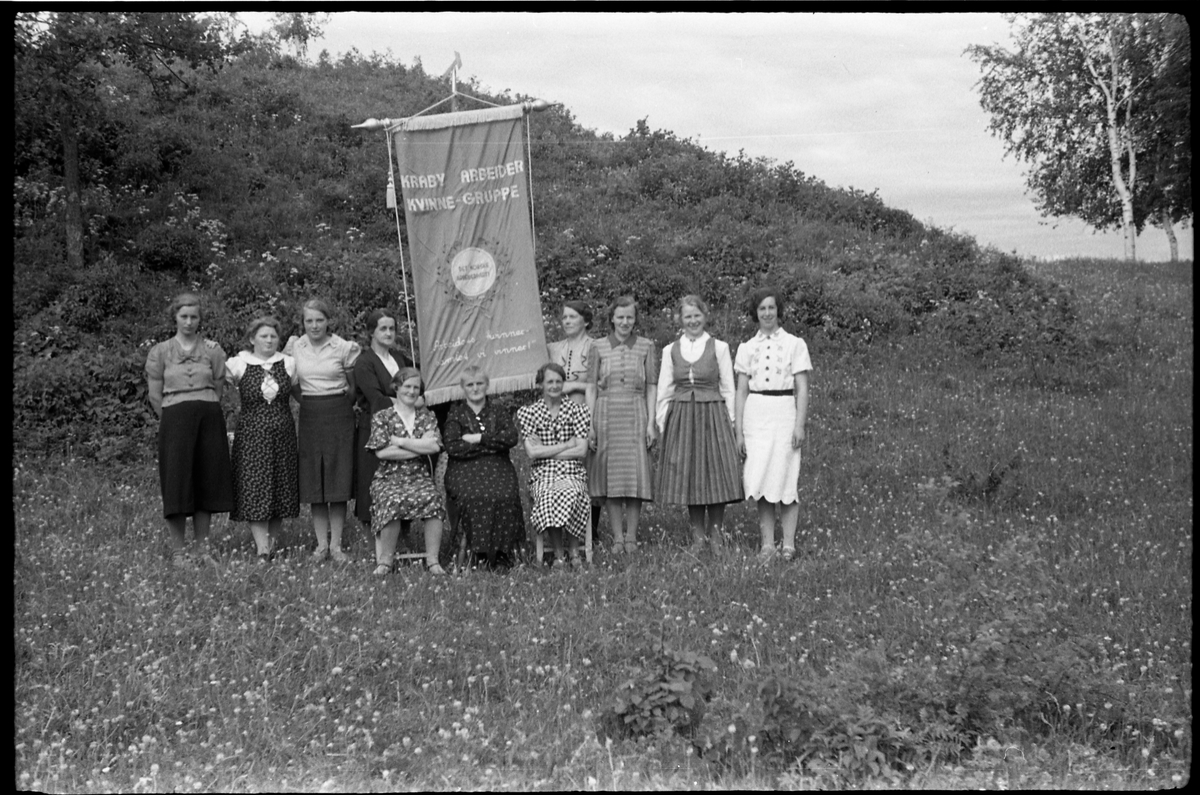 Kraby Arbeiderkvinnegruppe juni 1939. Bildene kan være tatt i forbindelse med at gruppa hadde sin nye fane klar. Serie på 6 bilder. Personene (bilde nr. 1):
Sittende foran fra venstre: Mally Tallerud, Ågot Lier, Nelly Moen. 
Bak fra venstre: Telma Moen, Ellen Lieshagen, Palma Gihleengen, Asta Hansen, Jeanette Tallerud, Mally Solberg, Marie Johansen, Anna Lieshagen.