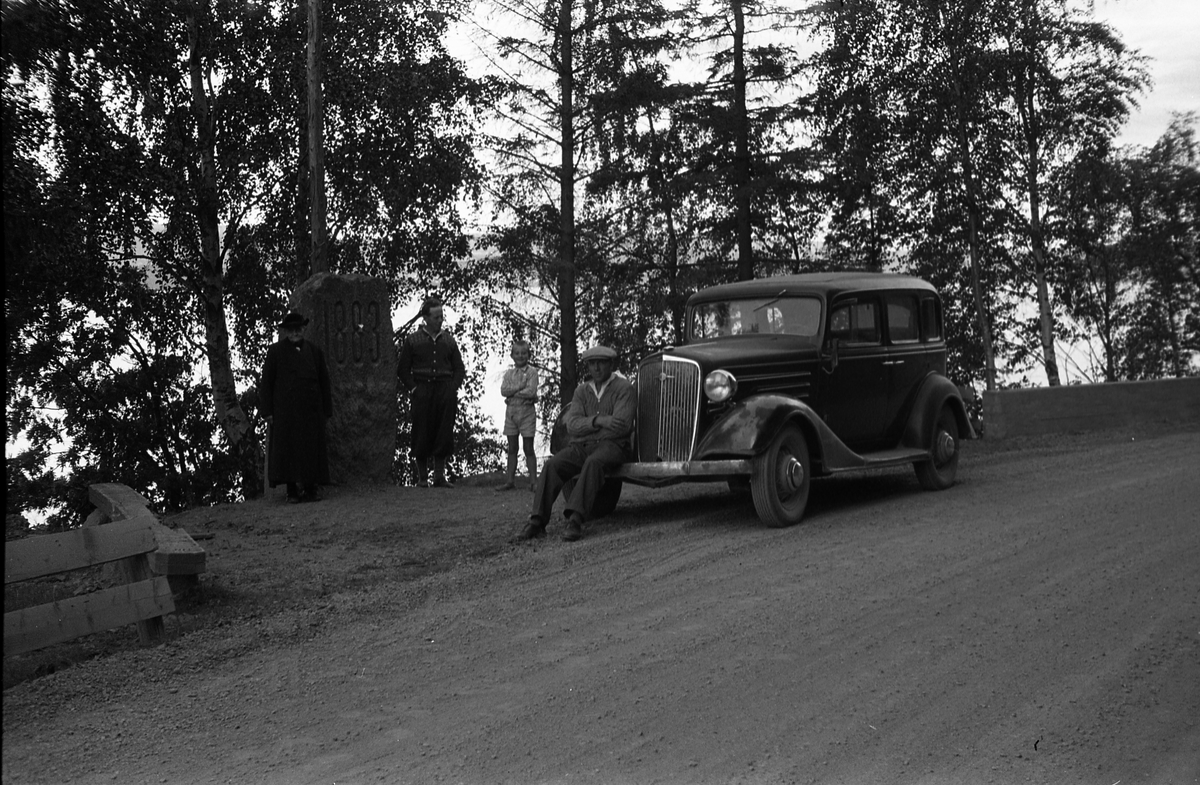 Rasteplass ved Falken i Skreifjella. Personene fra venstre: Othilie Nøkleby, Per Nøkleby, Kjell Røisli, Kåre Nøkleby. Plassen er ved merkesteinen for åpningen av vegen i 1883. Bilen er iflg. informant en Chevrolet 1934-modell.