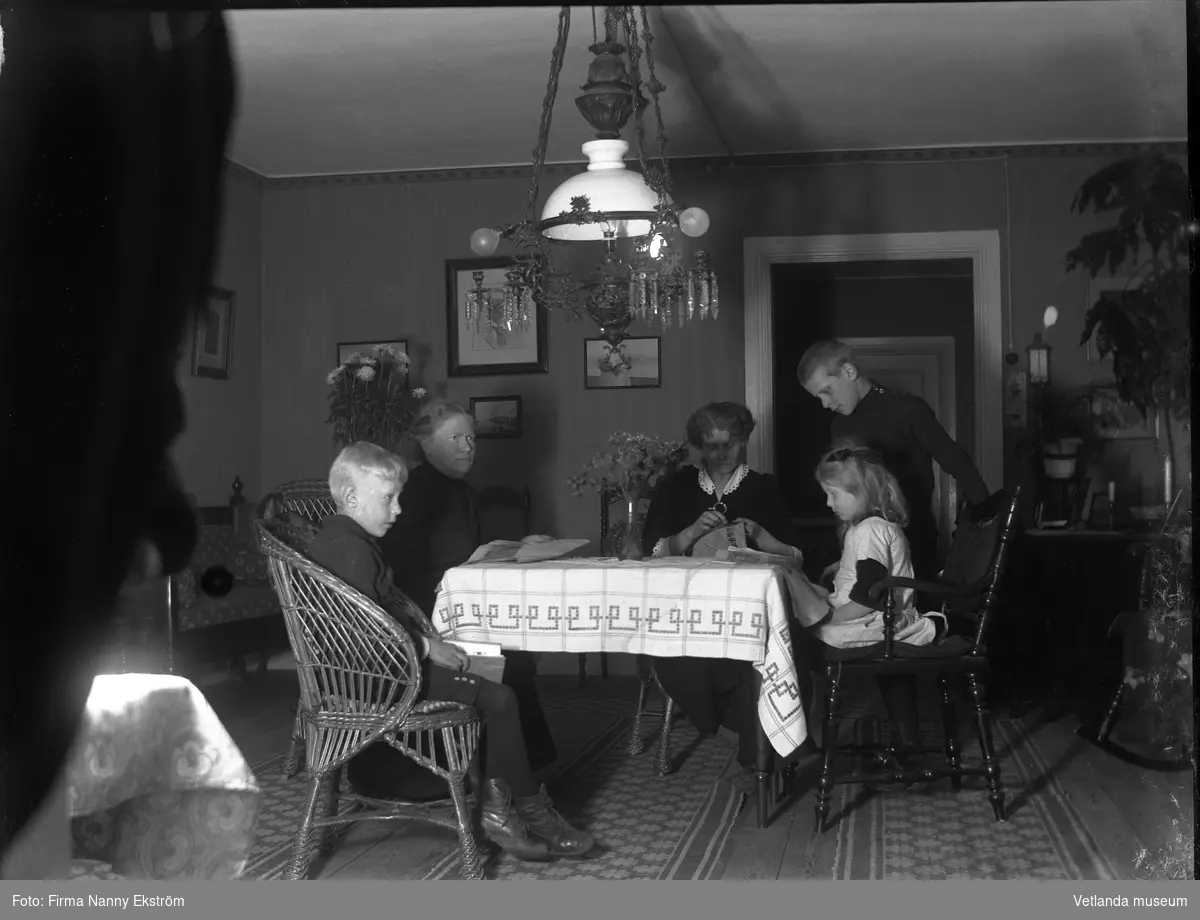 Två kvinnor och tre barn runt ett bord.