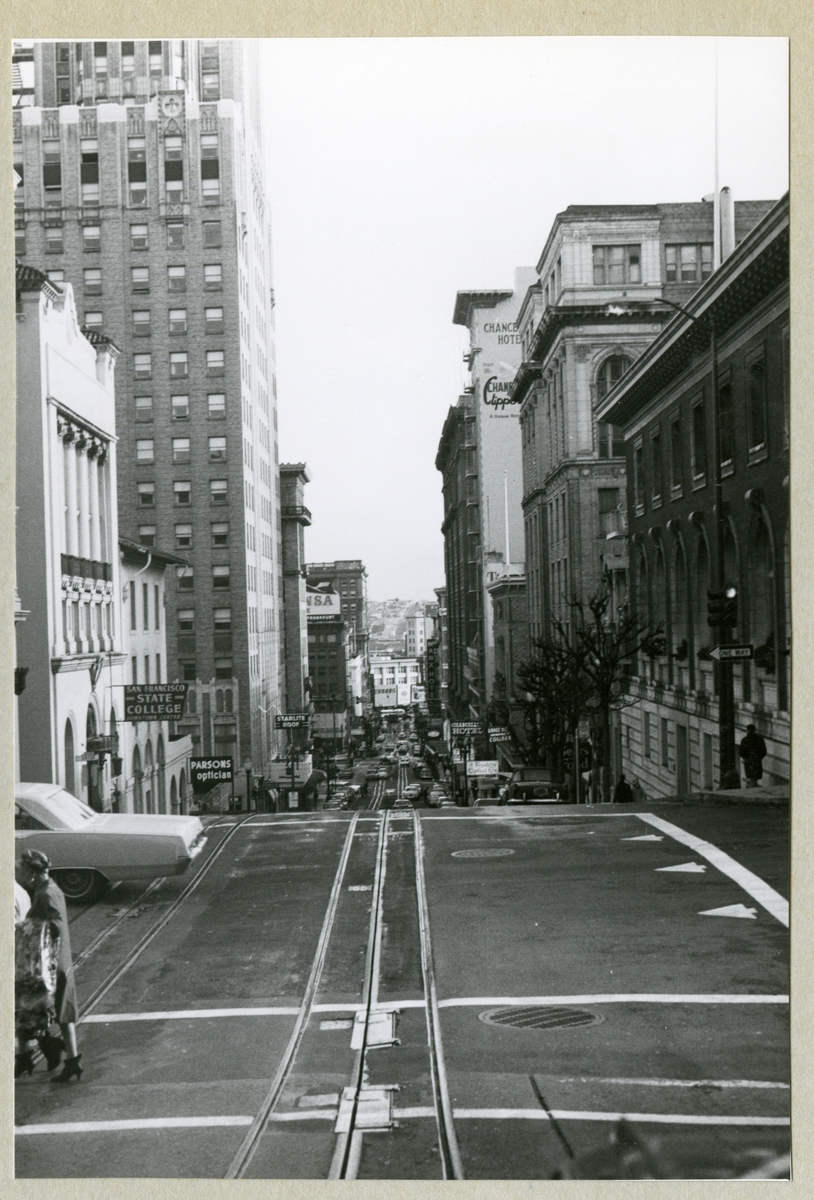 Bilden föreställer Powell street i San Francisco med höghus, hotell, gator, skyltar och bilar. Bilden är tagen i samband med minfartyget Älvsnabbens långresa 1966-1967.