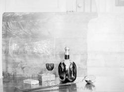 Stilleben, skjenkeflaske og glass, skrin og ause.