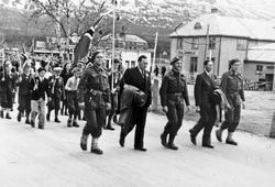 Menn i uniform, barn med flagg etter