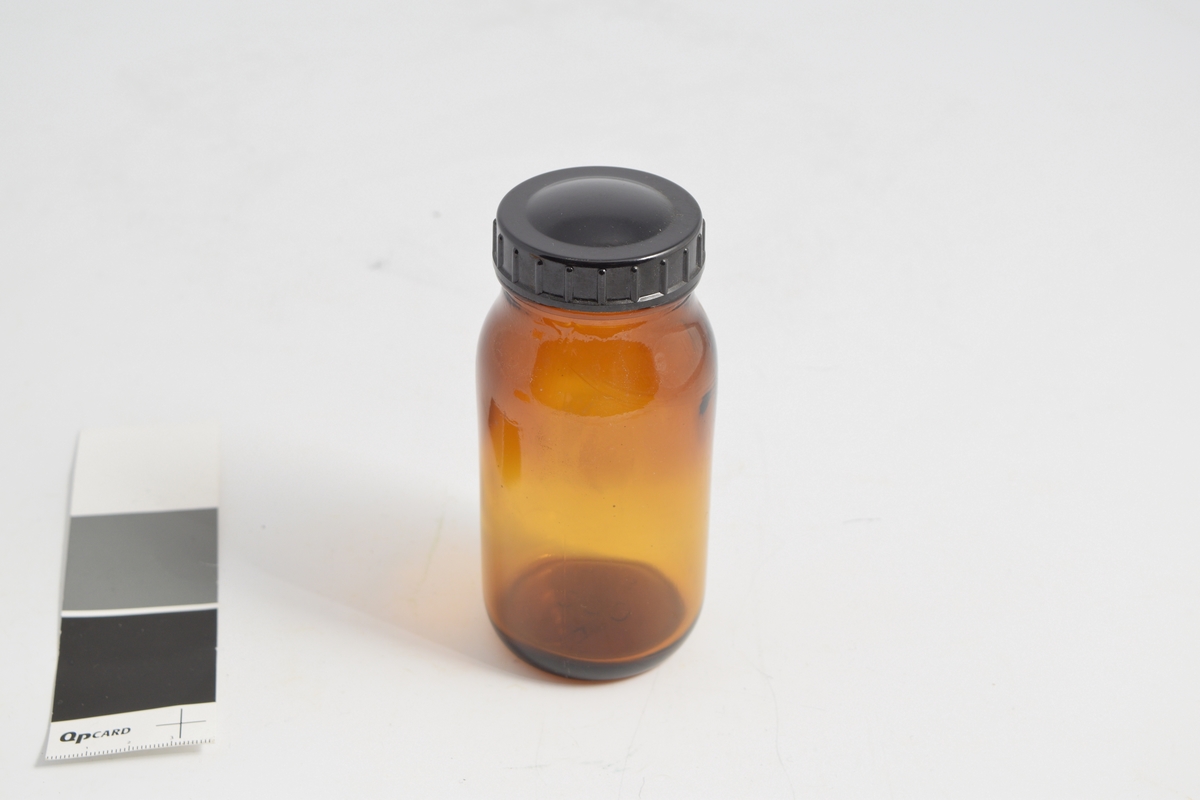 Apotekerflaske m/skrukork, 17 stk. Brune runde glasskrukker med sort bakkelitt lokk. Brukt til oppbevaring og slag av tabletter.