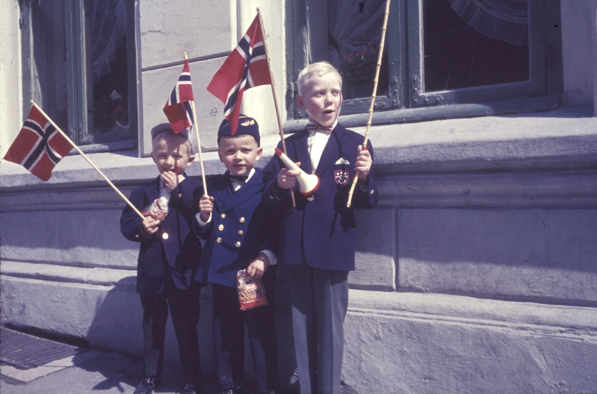 17. mai 1963. Bildet er tatt utenfor stuevinduet til familien Nilsen. I midten står Frode Nilsen. Gutten lengst til høyre er Arild Steine. Gutten lengst til høyre er muligens Stein Færø.