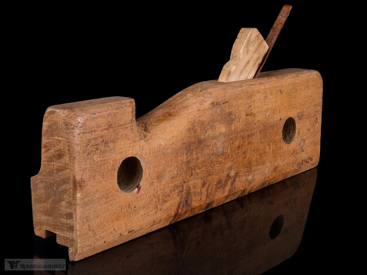 Smal rektangulær høvelstokk med tilskåret horn i forkant og avrundede hjørner. To gjennomgående opphengshull. Stokken er skåret slik at det er en støttekant ved siden av sålen. Gaffelformet høvelblad der et spor går langs sålen mellom de to tennene for høvling av fjær.