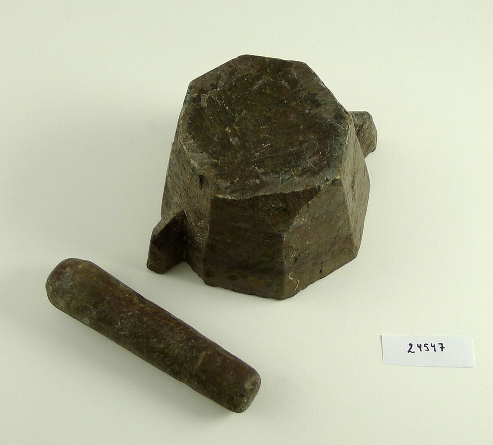 8-kantig mortel i kalksten med ornerade sidor. Stöt av samma sten.