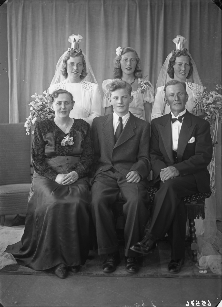 Gruppebilde. Familiegruppe på seks. To bruder, søstre, kvinne, mann og ung mann Bestilt av Einar Svanberg, Ole Ingvald Nøkling, Herr Kolstø.