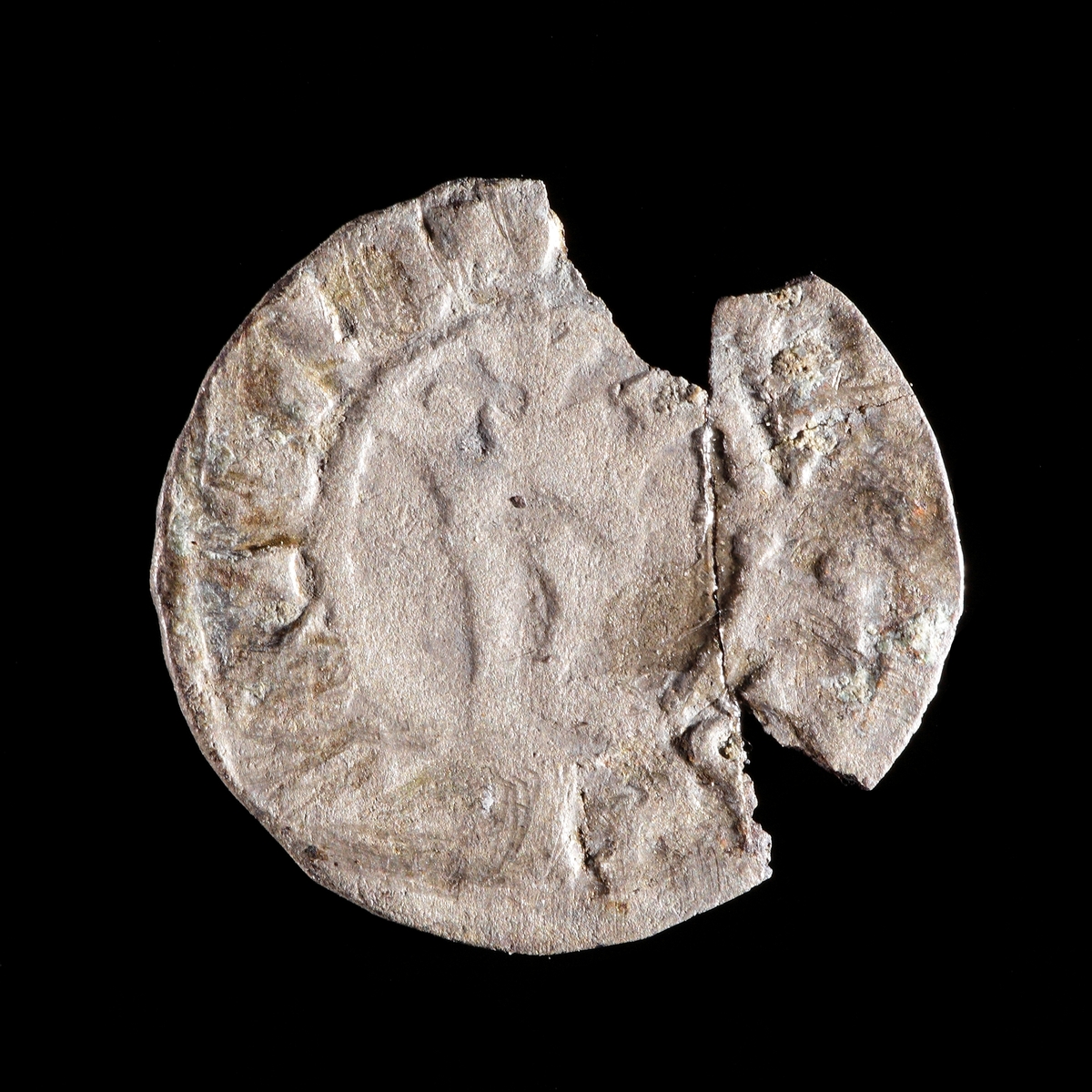 1 hvid silvermynt, Kristian I, Danmark (Galster 23d samt Hgb s. 186:35). Åtsida med krönt R och frånsida med kors. Lagad, men i sönderfall.