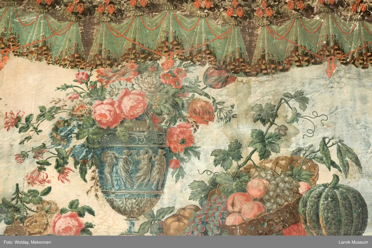 |Tapeten er påmalt tapetborder og brystning. Fra Hovland gård i Larvik.
Den øverste, brede borden: Gerlander/draperi med blomsterranker.
Den nederste, smalere borden: Tekstilbord med blomster. Øver døren til høyre: Stillebenmotiv med blomster og frukt.