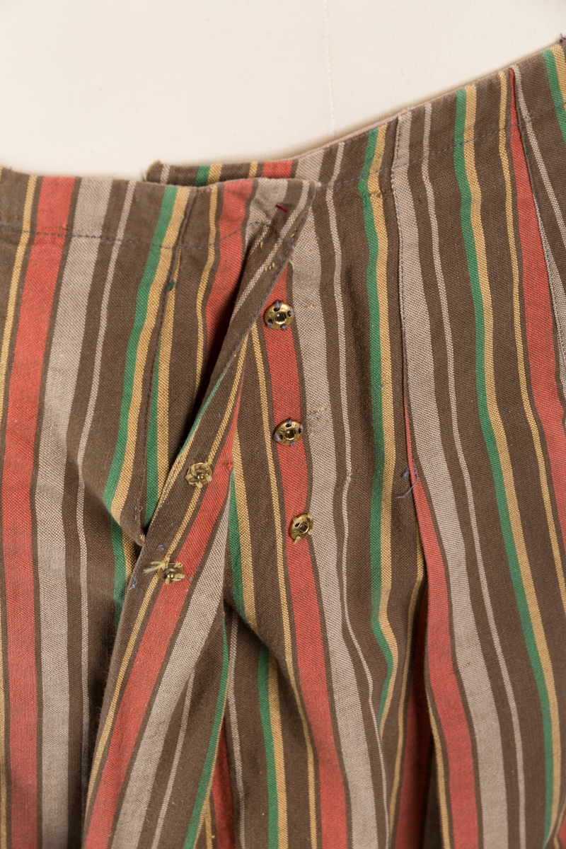 Stripete bomullsskjørt med nedsydde legg, uten linning, lukkes med trykknapper.